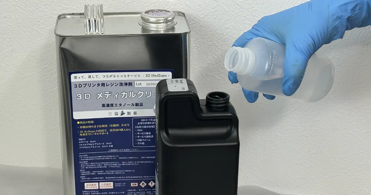 レジンカートリッジ内部を洗浄液 3D Medsupoで洗浄するために注ぎ入れている手元写真