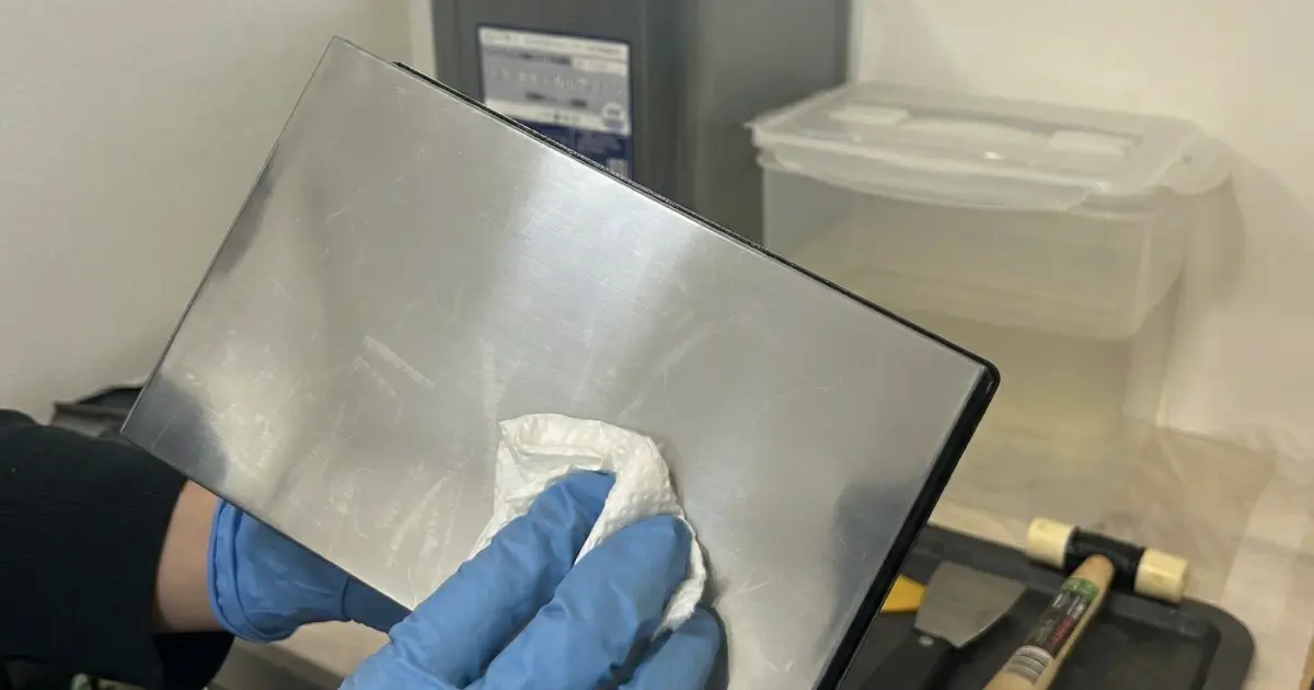 Form 4 ビルドプラットフォームの金属面を拭き上げている様子。一滴のレジンも残っていないピカピカの状態。