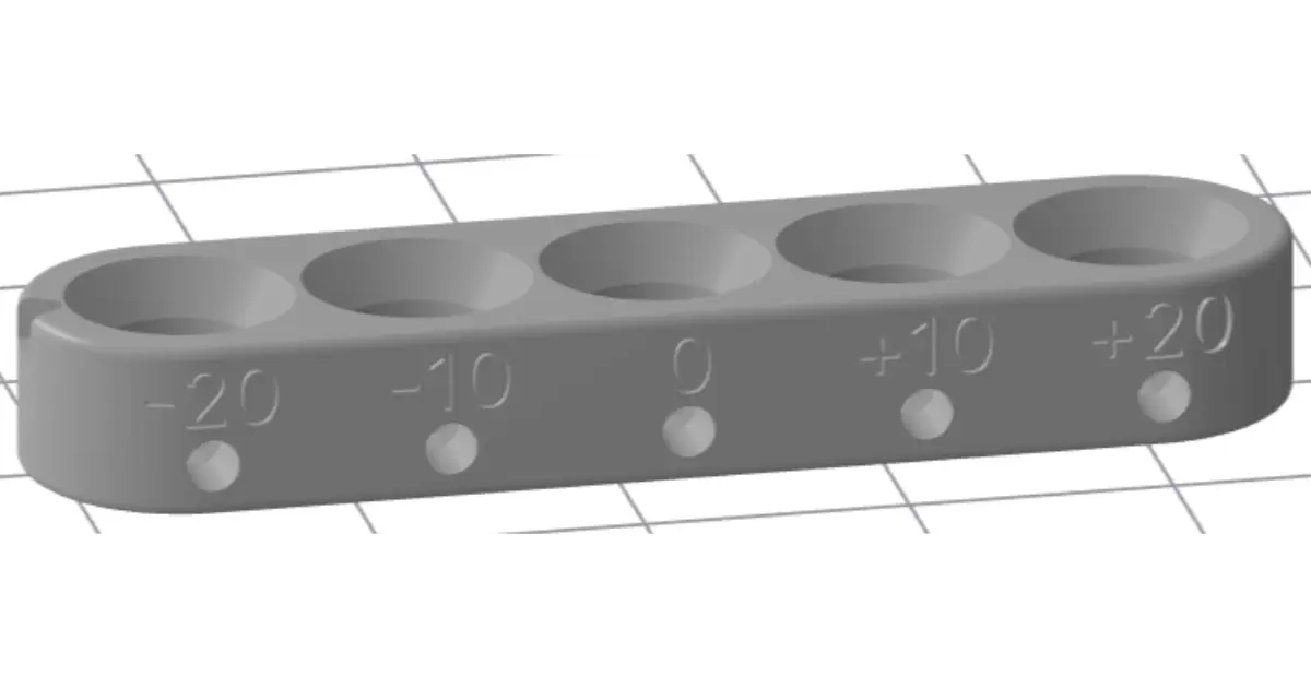 フィットチューニングブロックの穴にボールベアリングを挿入し、嵌合具合を確認している手元