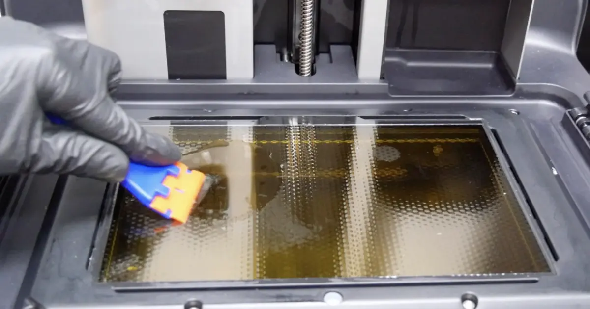 プラスチックスクレーパーを極めて浅い角度でLPU表面に当てている様子