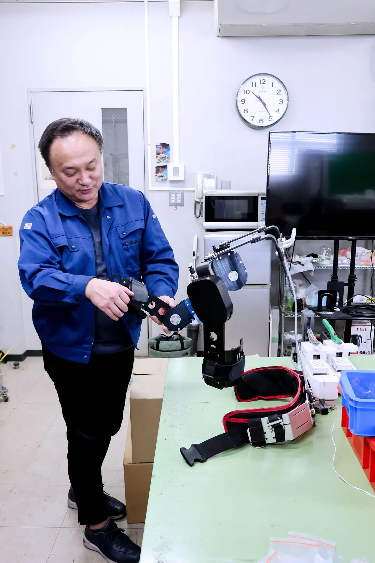新家教授がパワーアシストスーツを手に取る様子