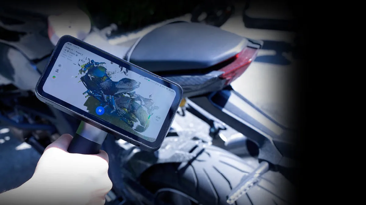 屋外の日なたでバイクをスキャンし、本体画面にデータが出ている様子
