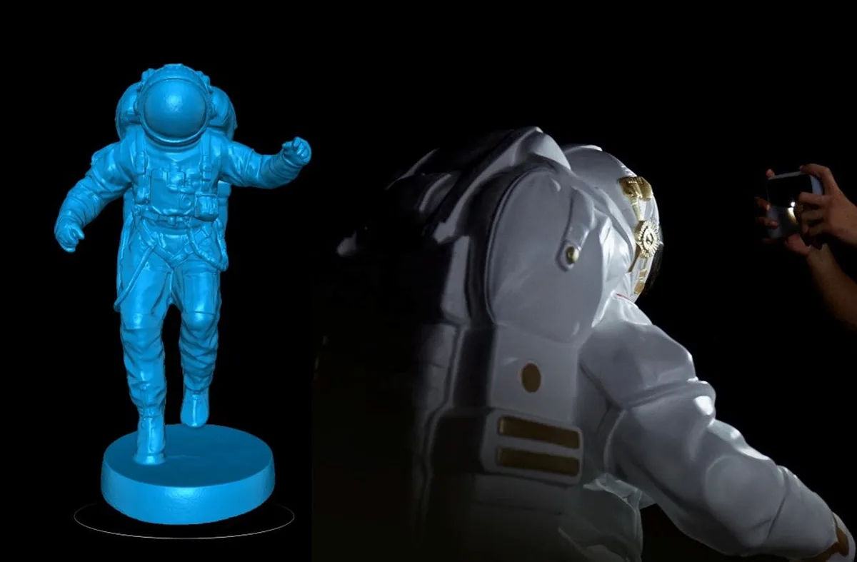 暗い室内で白い宇宙飛行士像をスキャンし、隣に取得した 3D データが並ぶところ