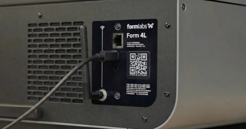 Form 4L の背面パネル。アンテナと有線 LAN の差込口の下にあるポートへ、黒いケーブルが接続されている