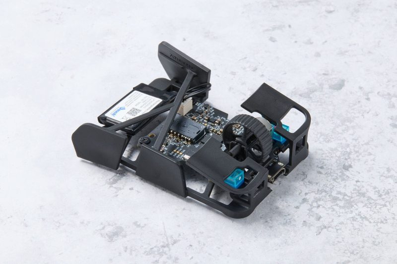 黒い筐体に基板と車輪を組み込んだ小型機器の試作品