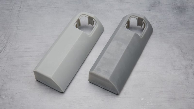 同じ形のグレーのカバー部品 2 個。左はマットで不透明、右はやや光沢がある