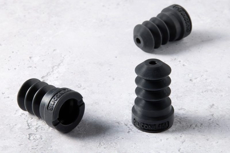 石目の台に置いた、SILICONE 40A と刻印された黒いベローズ部品 3 個