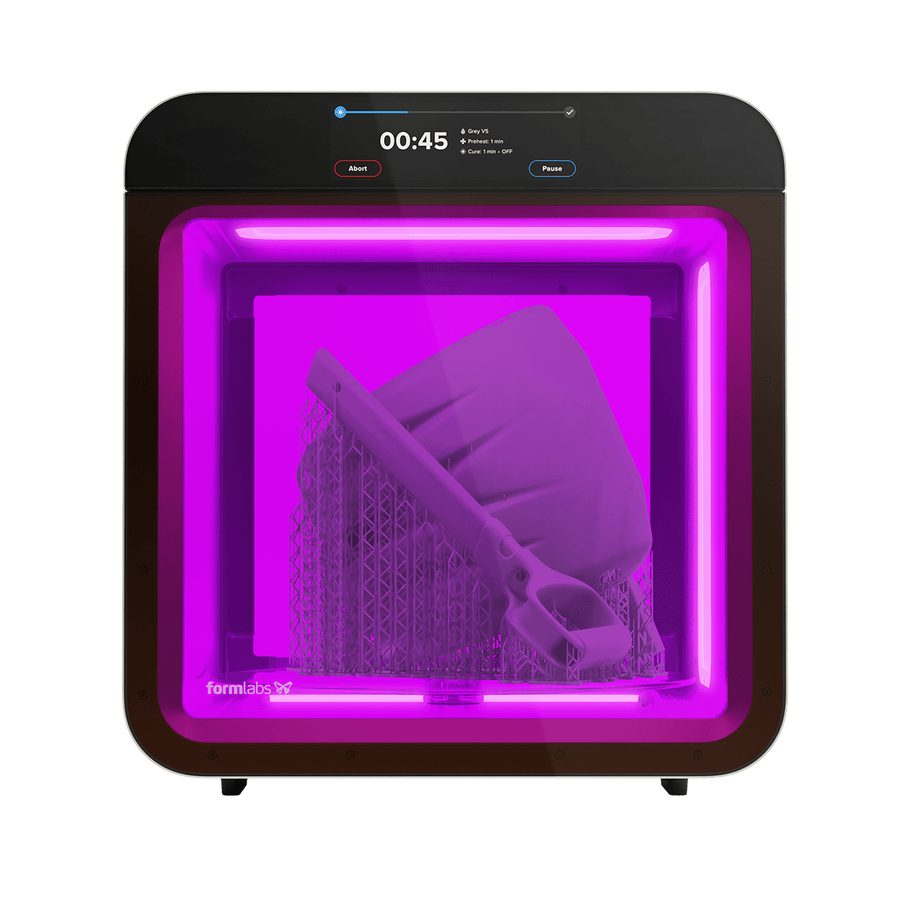 Form Cure L（V2）の正面。庫内が紫色に光り、ガラス製ターンテーブルの上でサポート付きの大型パーツを硬化中。上部のパネルに 00:45、Grey V5、Preheat: 1 min、Cure: 1 min の表示