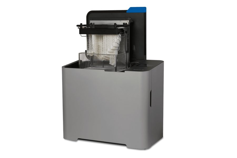 Form Wash L（第 2 世代）を斜め前から見たところ。上部ハッチを開き、サポート付きの白い造形品を吊り下げたビルドプラットフォームと、その下の金属製洗浄バスケットが見える