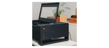Beambox II の蓋を開けた状態を側面寄りから見た写真 庫内前面の非常停止ボタンとUSBポートが見える