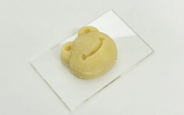 アクリル板に置いたカエルの形の饅頭
